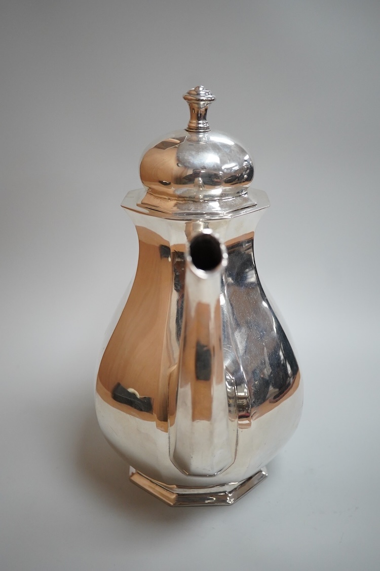 A white metal octagonal coffee pot with hinged cover, (tests as a low grade silver), on octagonal foot, height 23cm, gross weight 21oz.